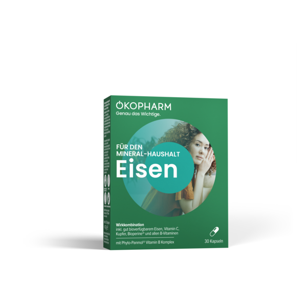Packung für Nahrungsergänzungsmittel mit Eisen, grün, enthält Vitamin C, Kupfer und B-Vitamine, abgebildete Frau im Hintergrund.