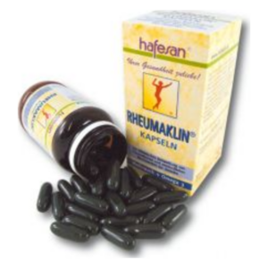 Eine geöffnete Flasche mit schwarzen Kapseln und einer dazugehörigen Verpackung von Rheumaklin.