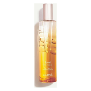 Transparente Flasche mit goldgelbem Duftwasser, schmalem Sprühkopf und Aufschrift "Soleil des Vignes" von Caudalie.