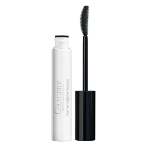 Eine Packung Mascara mit weißem Körper und schwarzem Deckel, daneben eine Bürste mit feinen Borsten.