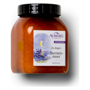 Glasbehälter mit orangefarbenem Badesalz, Label mit dem Titel 'Sternenmeer' von Dr. Klade, betont Entspannung.