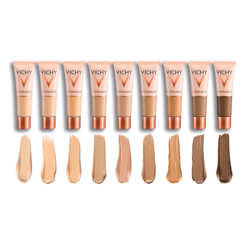 Verschiedene Farbnuancen von Vichy Make-up in Tuben, mit passenden Farbpigmenten auf einem weißen Hintergrund.
